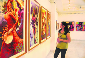 A girl looks at paintings on display during an art exhibition organised by the Chandigarh Art College Old Students Association at Virsa Vihar in Jalandhar on Wednesday.