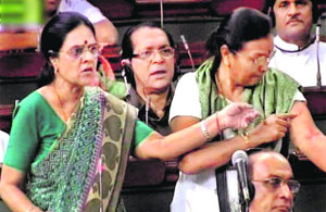 Congress MP Girija Vyas (L) points to injury marks on the arm of party MP Prabha Kishore Taviad, in the Lok Sabha in New Delhi on Wednesday. 