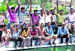 Bus drivers and conductors associated with the Garhwal Motors Transport Work Union protest on the bus rooftops 