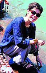 A foreigner fills plastic bottles with Ganga water at Har-Ki-Pauri in Haridwar