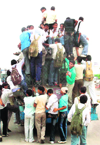 Passengers risk their lives while trying to board an overcrowded bus in Palwal.
