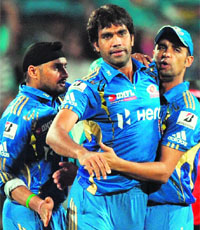 Mumbai Indians Harbhajan Singh (L) and Robin Peterson (R) congratulate team mate Munaf Patel after taking the wicket of Pune Warriors Robin Uthappa and Mumbai Indians in Pune on Thursday. Mumbai won by 1 run. 