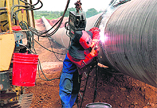 A Chinese engineer welding carbon steel pipes as part of the construction of a gas pipeline for Reliance Industries Ltd at Medak, some 175 km from Hyderabad. The government has asked the energy major to pay a US $1.25 billion penalty for a fall in gas production from its main oilfields, a Reliance executive said on Friday. 