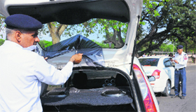 A traffic policeman removes a black film from a car in Chandigarh on Friday.