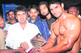 Roorkee MLA Pradeep Batra bestows the title of Iron Man on Rajbeer at a body building championship at Nehru Stadium in Roorkee on Thursday.