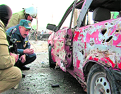 Investigators work at the site where two bombs exploded in Makhachkala