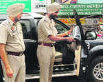 Police personnel remove black film from a window of a vehicle in Amritsar 