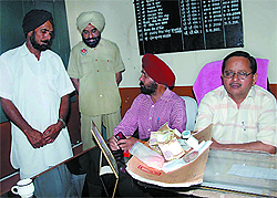 Jail Superintendent PK Garg (extreme right) looks at the cash and drugs seized after a warder (second from left) was caught supplying them to the inmates of Bathinda Central Jail on Saturday