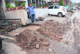 A resident shows the leaking pipeline in front of his house in Sector 45, Chandigarh, on Saturday
