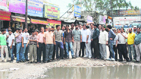Shopkeepers stage a protest against the delay in road repair by the Municipal Committee in Katra on Saturday.