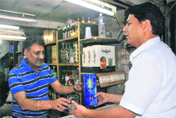 A buyer gets a gift with a liquor bottle at a vend in Sector 42, Chandigarh, on Sunday.