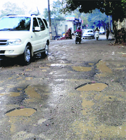 The Dehra-Chintpurni road is dotted with potholes, giving a tough time to motorists.