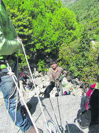 A visually impaired trekker does rock climbing.
