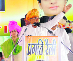 Chief Minister Bhupinder Singh Hooda addresses a pragati rally at Nangal Chaudhary in Mahendragarh district on Sunday as Shruti Chaudhary, MP, looks on. 