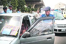 A traffic policeman removes a tinted film from a car near Dogra Chowk in Jammu on Sunday. 