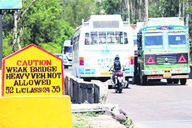 Heavy vehicles continue to move on a bridge that has officially been declared unsafe for heavy vehicles, putting the lives of passengers at risk, near Nagrota town on the Jammu-Srinagar national highway. 