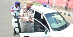 Police personnel remove black films from a car in Patiala.