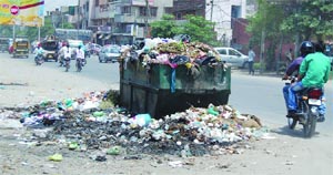 In the absence of lifting, garbage spills out of a dump container in Amritsar on Monday. 