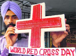 Artist Gurpreet Singh uses 650 capsules to create the symbol of Red Cross on the eve of the World Red Cross Day in Amritsar on Monday. 