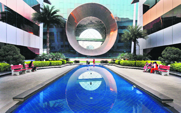 Employees walk in front of a building dubbed the "washing machine", a well-known landmark built by Infosys at the Electronics City IT district in Bangalore. The first signs all was not well at Infosys came a year ago with a disappointing sales forecast and the unexpected resignation of an executive many had expected to be its next CEO. Infosys has come to define an industry that symbolises modern entrepreneurial India.  Reuters