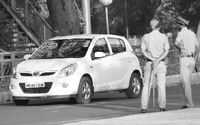 A car with tinted glass drives past two policemen in Mohali on Monday. 