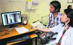 An official tries her hand at the new computerised X-Ray. Tribune photo: manoj mahajan
