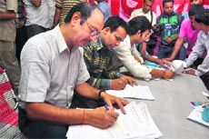 Applicants fill in forms for the Amarnath yatra at a J&K Bank registration counter in Jammu on Monday. 