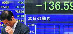 A man looks down in front of an electronic board displaying the closing stock prices. Japan's Nikkei share average fell 1.5% on Wednesday to a fresh three-month closing low as concerns grew that Greece could reject its hard-won bailout deal with international lenders that saved it from a disruptive bankruptcy