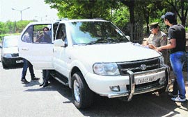 A police official challans a vehicle-owner for the use of black film near the roundabout separating Sectors 40 and 41 in Chandigarh on Wednesday