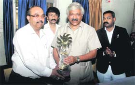 Planning and Sports Minister Dinesh Aggarwal (right) being honoured by Surinder Pundir, president of the Dehradun Bar Association, at a function on Wednesday