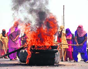 Villagers burn tyres at Subhash Chowk to protest against the Haryana Urban Development Authoritys demolition drive in Islampur (Gurgaon) on Wednesday.