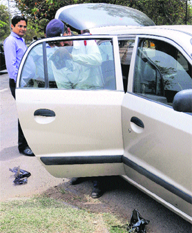 A traffic policeman removes black films from a vehicle in Chandigarh.