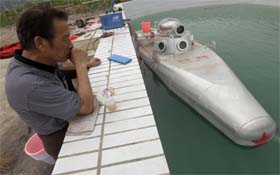 An engineer working for Zhang Wuyi looks at a double-seater submarine during a test operation at an artificial pool near a shipyard in Wuhan, Hubei province, China