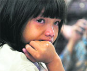 Six-year-old Olivia cries as she and her family wait for information about her missing Indonesian father Steve Kamagi, one of the passengers of the ill-fated jet. 