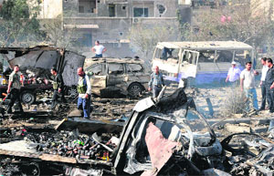 Security forces inspect the site of twin blasts in Damascus on Thursday. 