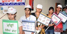 NSS volunteers carry placards with the Mothers Day slogans written on them, at the SSD Girls College in Bathinda, on Saturday.