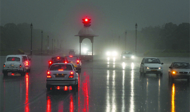 Drivers struggle through their way on Rajpath as visibility drops during the rain on Saturday evening.