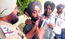 Traffic police personnel use an alchometer during a challan drive in Jalandhar
