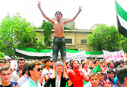 A Syrian protester flashes the victory sign during a protest in the town of Kfar Nubul, near Idlib
