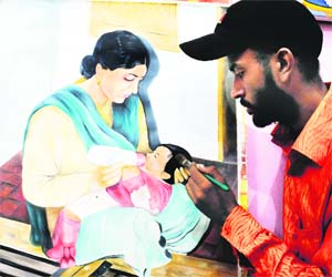 Portrait of the creator Artist Rubel gives finishing touches to a portrait dedicated to his mother on the occasion of Mothers Day in Amritsar on Sunday. 