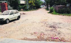 Potholed roads and garbage scattered on the roadsides at Mission Compound area of Amritsar. 