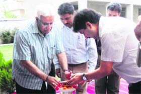 Vijay Bakaya, MLC and former Chief Secretary (left), lights the traditional lamp during an awareness programme on global warming in Jammu on Sunday