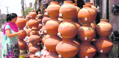 A woman chooses a pitcher put up for sale on a roadside in Ludhiana.