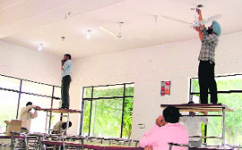 PAU employees install fans at the students centre canteen hall.