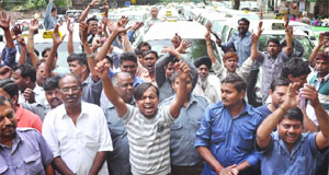 Activists of the Economy Radio Taxi Drivers Association shout slogans during their procession from the Ramlila Grounds to Jantar Mantar, demanding the setting up of  prepaid booths for radio taxis at railway stations and exemption of MCD toll tax for them in New Delhi on Monday. 