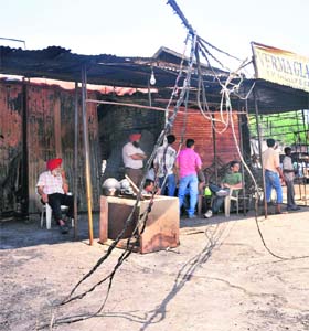 Burnt electric cables hang at the furniture market where a fire broke our on Monday