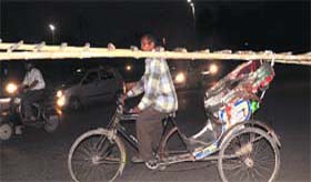A rickshaw-puller carries a ladder in a dangerous way at Sector 45 in Chandigarh on Tuesday