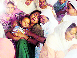 The wife of constable Gurpaljit Singh breaks down on learning about his death in an accident near Jagraon on Tuesday