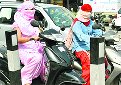 These young girls in Patiala choose to drive their scooters with their faces covered to escape the scorching summer heat