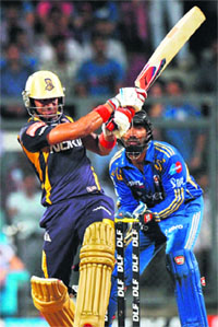 Kolkata Knight Riders Manoj Tiwary (L) plays a shot as Mumbai Indians wicketkeeper Dinesh Karthik looks on in Mumbai on Wednesday. 